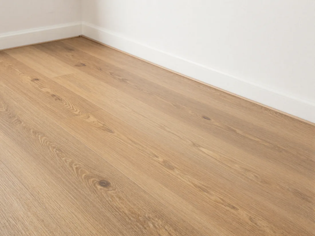 Newly laid wood-effect flooring with crisp white skirting